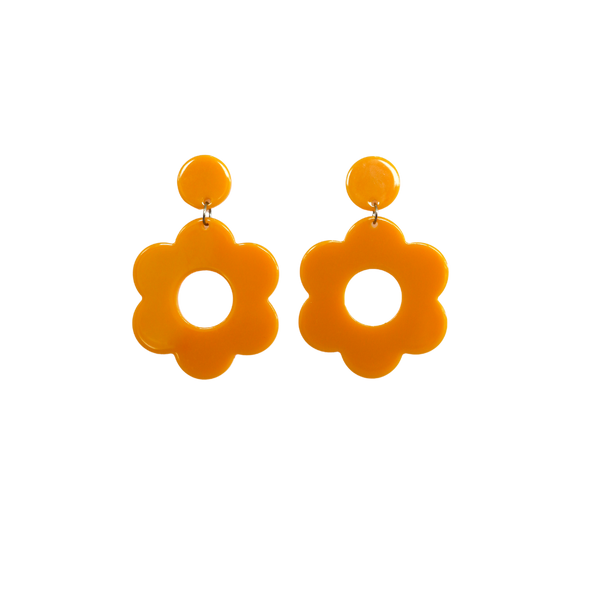A pair of light brown bold and playful statement earrings in a retro-inspired daisy flower design. The earring has a large, light brown acrylic flower with a circular cutout center, hanging from a matching light brown circular stud. The petals are rounded, giving off a fun, 70's style playful vibe!!