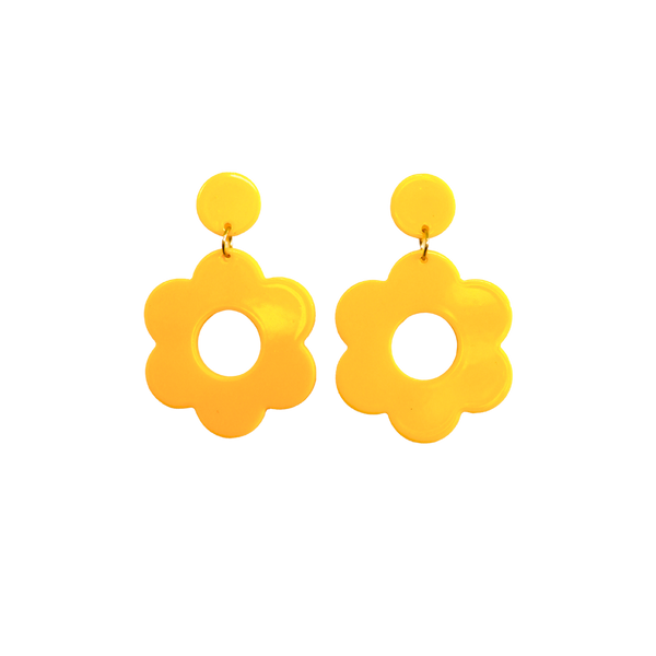 A pair of yellow bold and playful statement earrings in a retro-inspired daisy flower design. The earring has a large, yellow acrylic flower with a circular cutout center, hanging from a matching yellow circular stud. The petals are rounded, giving off a fun, 70's style groovy vibe!!
