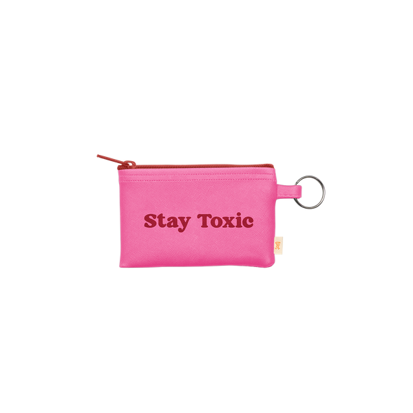 A multi functional small zippered pouch with a gold key ring. The saying "Stay Toxic" as well as the zipper is red while the main color of the pouch is bright pink.