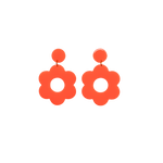 A pair of red bold and playful statement earrings in a retro-inspired daisy flower design. The earring has a large, red acrylic flower with a circular cutout center, hanging from a matching pink circular stud. The petals are rounded, giving off a fun, 70's style groovy vibe!!