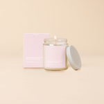 Deep breathes in" soy candle in a clear glass jar with minimalist light pink label and lid, featuring bold, humorous text and matching gift box – scented with notes of sweet citrus and berries.