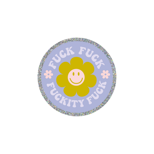 This is a round sticker with a silver glitter boarder. The background is lavender with a green smiley face flower in the center. The words "FUCK FUCK FUCKITY FUCK" are surrounding the green smiley face flower with two small daisy flowers are on either side of the center smiley face flower.