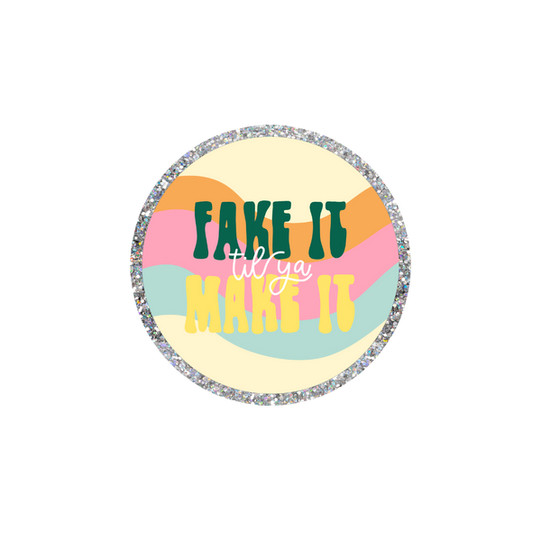 This a a round sticker with a silver glitter boarder. The background is wavy stripes in light yellow, pink, and turquoise. The text reads "FAKE IT" in hunter green, "til you" in white cursive and "MAKE IT" in yellow. 