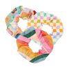 A set of 3 super cute scrunchies made out of life proof/rip proof materials in funky trippy patterns in an array of colors ranging from orange to lime green, purple, and blues, checker board pattern and colorful waves.