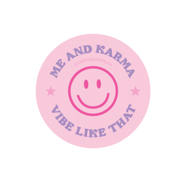 A circle shaped sticker with a light pink background. Te sticker is a bright pink smilie face in the center with the saying "ME AND KARMA VIBE LIKE THAT" written in purple.
