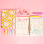 Flower Check Bullet Journal – Aesthetic & Organized
Say hello to your cutest companion for planning and productivity. With a groovy pink-and-mustard checkered cover and smiley daisies all over, this bullet journal is pure serotonin. Inside, enjoy smooth dot-grid pages ready for trackers, goals, doodles, or chaos. Ideal for creatives, list-makers, or anyone who writes things just to check them off.
