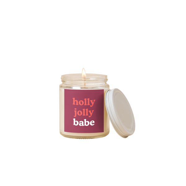 8 oz candle jar with maroon colored label on front with text that reads "holly jolly babe" in red and white letters.