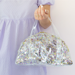 Lady in purple dress holding confetti Lil Miss Sunshine.