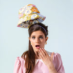 Cute floral hat floating above a with a shocked facial expression.