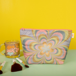 Mustard yellow background with a 'dont talk to me" glass mug with smiley faces on it and a medium puffy kaleidoscope floral tweedle dee on a pastel green surface.