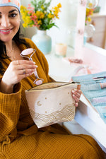 Canvas toiletry bag with leather tab detail and metal zipper, gold wrapped hills with moon and stars