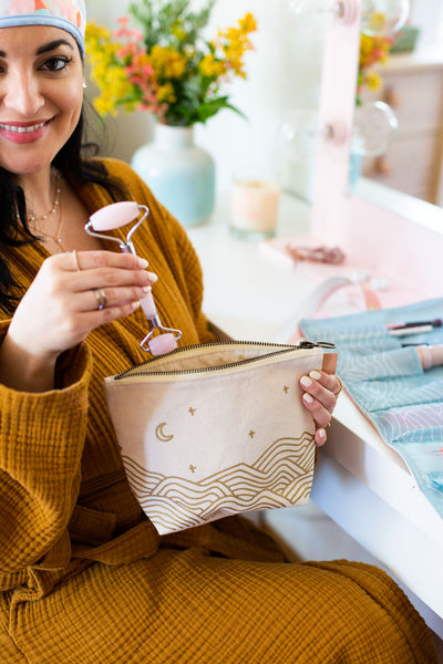 Canvas toiletry bag with leather tab detail and metal zipper, gold wrapped hills with moon and stars
