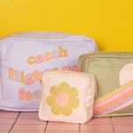 Mustard yellow background with three waffle pouches on a pink squared surface.