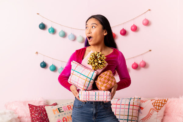 Model holding two large plaid holiday busy bee and one medium checkered holiday busy bee bag.