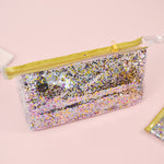 Travel cosmetics pouch in clear vinyl with glitter confetti in small.