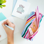 A wild-striped multicolored Ladybug pouch with two Jotters, washi tape, and other stationary displayed inside. A "Stay Cool" Igloo greeting card is displayed to the top left of the pouch.