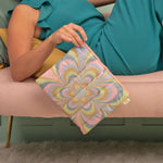 Girl laying on a pink couch holding a pastel color kaleidoscope floral pattern puffy  dollface 
