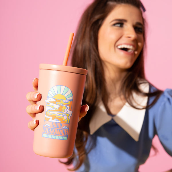 Good Vibrations Cold Cup
Sip in style with the Good Vibrations Cold Cup—a retro-inspired essential for keeping your favorite drinks chilled and your mood lifted. With a peachy matte finish and a groovy sunset graphic that radiates positivity, this cup doesn’t just hold your beverage—it holds the vibe. Double-walled for insulation and topped with a matching straw and lid, it's perfect for on-the-go hydration, sunny days, or your daily iced coffee ritual. Durable, reusable, and ridiculously cute—cheers to goo