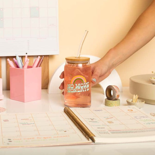 Desk setup with "No More Mondays" can glass w/lid + straw, 2 washi tapes, 1 small monthly planner, and an assortment of TOOT pens. 