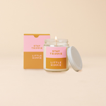 An 8 oz. candle w/ a lid and a split-colored decal (Pink and tan) with the phrase, "Stay trippie little hippie) printed on.