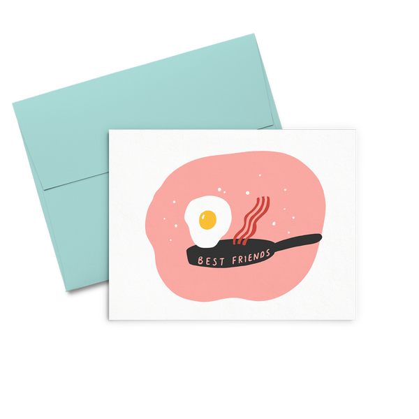 Letterpress greeting card with a cute fried egg and a piece of bacon jumping out of a skillet that says Best Friends all on a peachy circle background
