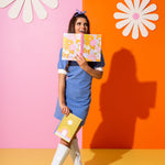 Lady in blue dress holding a floral pattern notebook and a colorful moon notebook.