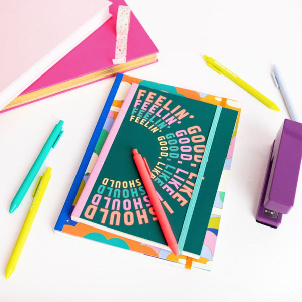 feelin' good like i should planner surrounded by jotter pens and a purple stapler.
