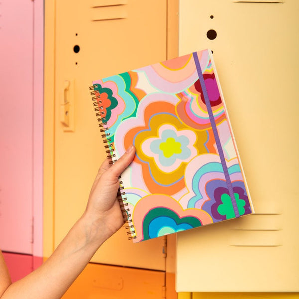 small goal getter planner with multicolor flowers all around the binder and a purple elastic band to keep it closed.