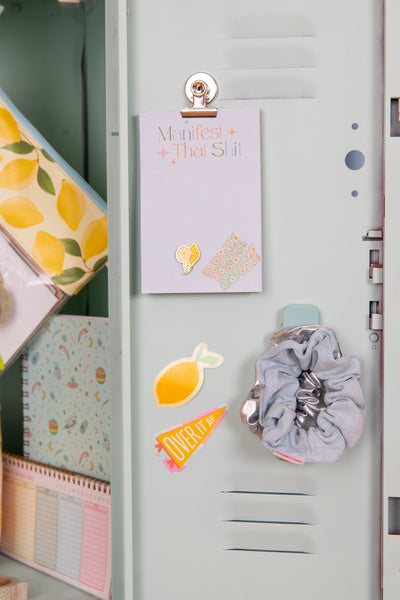 Small tearaway notepad inside of a teal locker door. 