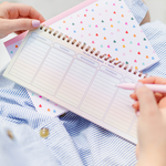 On the Horizon Weekly Deskpad laying on top of a Tiny Hearts Notebook. 