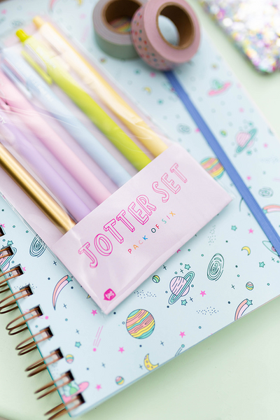 galactic cover of journal with set of pastel jotter pens and washi tape