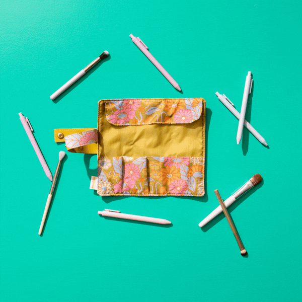 Gathering flowers small tootsie roll with misc items inside laying on a teal background.