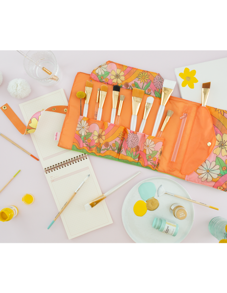large TOOTsie roll open with makeup and paint brushes with paint, canvas and sketch book