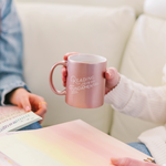 woman sitting writing notes in a notebook while holding rose gold cup reading is fundamental