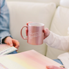 woman sitting writing notes in a notebook while holding rose gold cup reading is fundamental