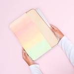 Hands holding a rainbow gradient laptop sleeve
