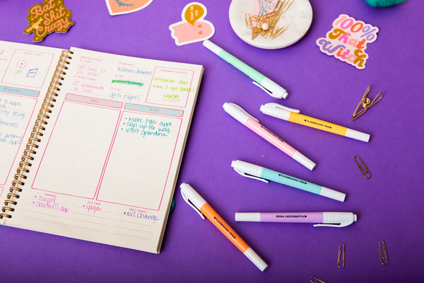 6 pastel highlighters displayed with an Academic planner and TOOT Halloween Stickers.
