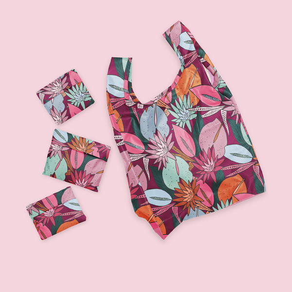 Small twist and shout with floral collage pattern with jewel tones. Patten laying open next to three twist and shouts folded up.