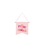 large hanging wall art on pink background with saying the future is female